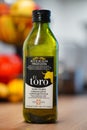 Bottle of El Toro brand olive oil sitting on a rustic wooden table.