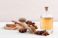 Bottle of essential oil, anise and seeds on white wooden table Royalty Free Stock Photo