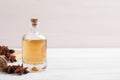 Bottle of essential oil, anise and seeds on white wooden table. Space for text Royalty Free Stock Photo