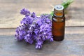 Bottle of essential oil and bouquet of  lavender flowers arranged on a wooden tabl Royalty Free Stock Photo