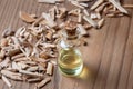 A bottle of cedar essential oil with cedar wood chips