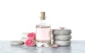 Bottle of essential oil, flowers and stones on table Royalty Free Stock Photo