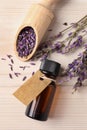 Bottle of essential oil and lavender flowers on white wooden table, flat lay Royalty Free Stock Photo