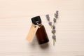 Bottle of essential oil and lavender flowers on white wooden table, flat lay Royalty Free Stock Photo