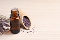 Bottle of essential oil and lavender flowers on white wooden table, space for text Royalty Free Stock Photo