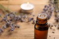 Bottle of essential oil and lavender flowers on wooden table, closeup. Space for text Royalty Free Stock Photo