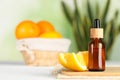 Bottle of essential oil and orange on white wooden table, space for text Royalty Free Stock Photo