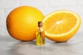 Bottle of essential oil with oranges on grey marble table, closeup Royalty Free Stock Photo