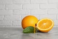 Bottle of essential oil with oranges and leaf on grey marble table against white brick wall. Space for text Royalty Free Stock Photo