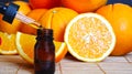 Bottle of essential oil from oranges on wooden background with pieces of oranges - alternative medicine. Essential aroma oil with Royalty Free Stock Photo