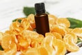 A bottle of essential oil and peeled mandarin wedges. Aroma and care and health. Close-up Royalty Free Stock Photo