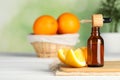 Bottle of essential oil, pipette and orange on white wooden table, space for text Royalty Free Stock Photo