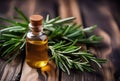 Bottle of essential oil and rosemary herb on a wooden table.