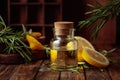 Bottle of essential oil, rosemary, and lemon on a wooden table Royalty Free Stock Photo