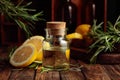 Bottle of essential oil, rosemary, and lemon on a wooden table Royalty Free Stock Photo