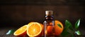 A bottle of essential oil among Valencia oranges and leaves on a wooden table Royalty Free Stock Photo