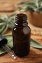 Bottle of essential sage oil, dropper and leaves on wooden table, closeup Royalty Free Stock Photo