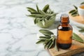 Bottle of essential sage oil and leaves on white marble table. Space for text Royalty Free Stock Photo