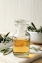 Bottle of essential sage oil and leaves on white wooden table, closeup Royalty Free Stock Photo