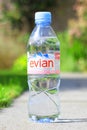 Bottle of Evian natural mineral water with sunny summer background