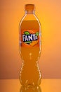 Bottle of Fanta drink on gradient background.