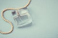 A bottle of female perfume with a pearl decoration Royalty Free Stock Photo