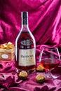 A bottle of French cognac Hennessy V.S.O.P with a glass of cognac and chocolates. Royalty Free Stock Photo