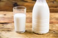 Bottle of fresh farm milk and glass of milk on wooden background. Side view. Royalty Free Stock Photo