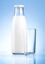 Bottle of fresh milk and blank glass on blue