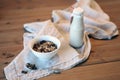 Bottle of fresh milk with Oat and whole wheat grains flake on wooden table. Bowl of muesli with frozen berries and bottle of plant Royalty Free Stock Photo