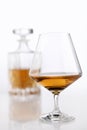 Bottle and glass of brandy on a white table Royalty Free Stock Photo