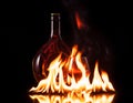 Bottle glass of cognac in fire flame Royalty Free Stock Photo