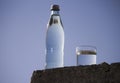 Bottle and glass with cold fresh water against the sky Royalty Free Stock Photo