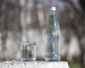 Bottle and glass with cold fresh water against the sky Royalty Free Stock Photo