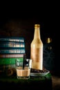 Bottle and glass with craft coffee alchol drink on background with books