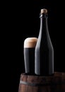 Bottle and glass of stout beer on wooden barrel Royalty Free Stock Photo