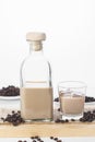 Bottle and glass of Cream coffee liqueur with ice, and coffee  beans on white rustic background Royalty Free Stock Photo