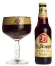 Bottle and glass of La Trappe Dubbel beer on a white background