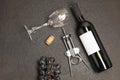 Bottle and glass of red wine with bunch of grapes,corkscrew, on black wooden table., top view Royalty Free Stock Photo