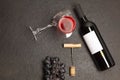 Bottle and glass of red wine with bunch of grapes,corkscrew, on black wooden table., top view Royalty Free Stock Photo