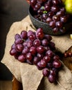 Bottle and glass of red wine, grape and cork on chair. Melon, piece of melon. Pink grape, pear. Still life of food. Dark