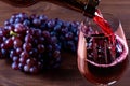 Bottle and glass of red wine, grape and cork on wooden background Royalty Free Stock Photo