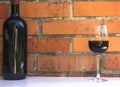 Bottle and glass of red wine near wall of orange bricks. loft st Royalty Free Stock Photo