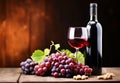 Bottle and glass of red wine next to a bunch of grapes with a blurred background Royalty Free Stock Photo