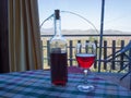 Bottle and glass of Sicilian red wine on the table covered with checkered tablecloth Royalty Free Stock Photo