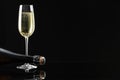 Bottle and glass of sparkling wine on black mirror surface. Space for text Royalty Free Stock Photo