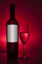 Bottle and glass with white wine on red background Royalty Free Stock Photo