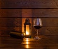 Bottle and glass of wine, candle in the night on a wooden brown background. Rest after a hard day. Royalty Free Stock Photo