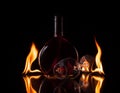 Bottle and glass of wine in fire flame Royalty Free Stock Photo