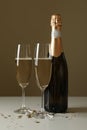 Bottle and glasses with champagne and glitter on white table